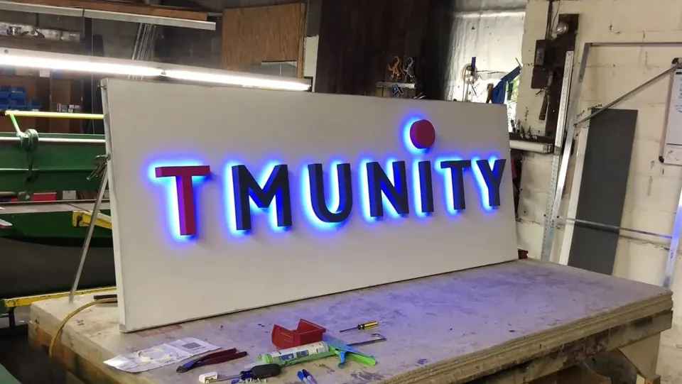 Illuminated channel letters being assembled on a fabrication workbench